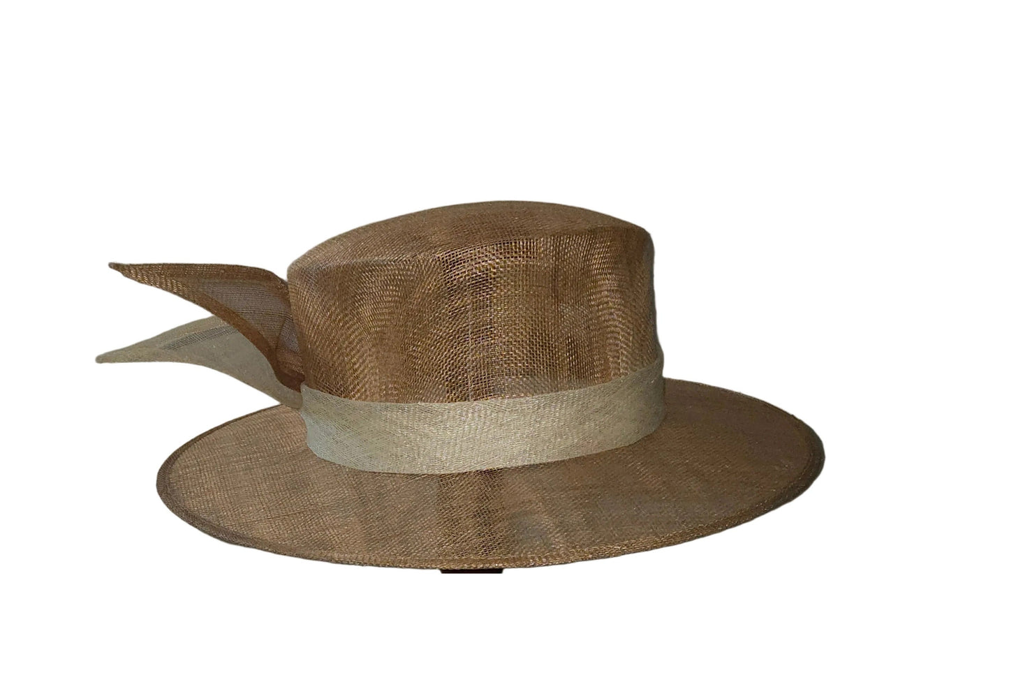 Brown straw hat on a wooden stand against a white wall.