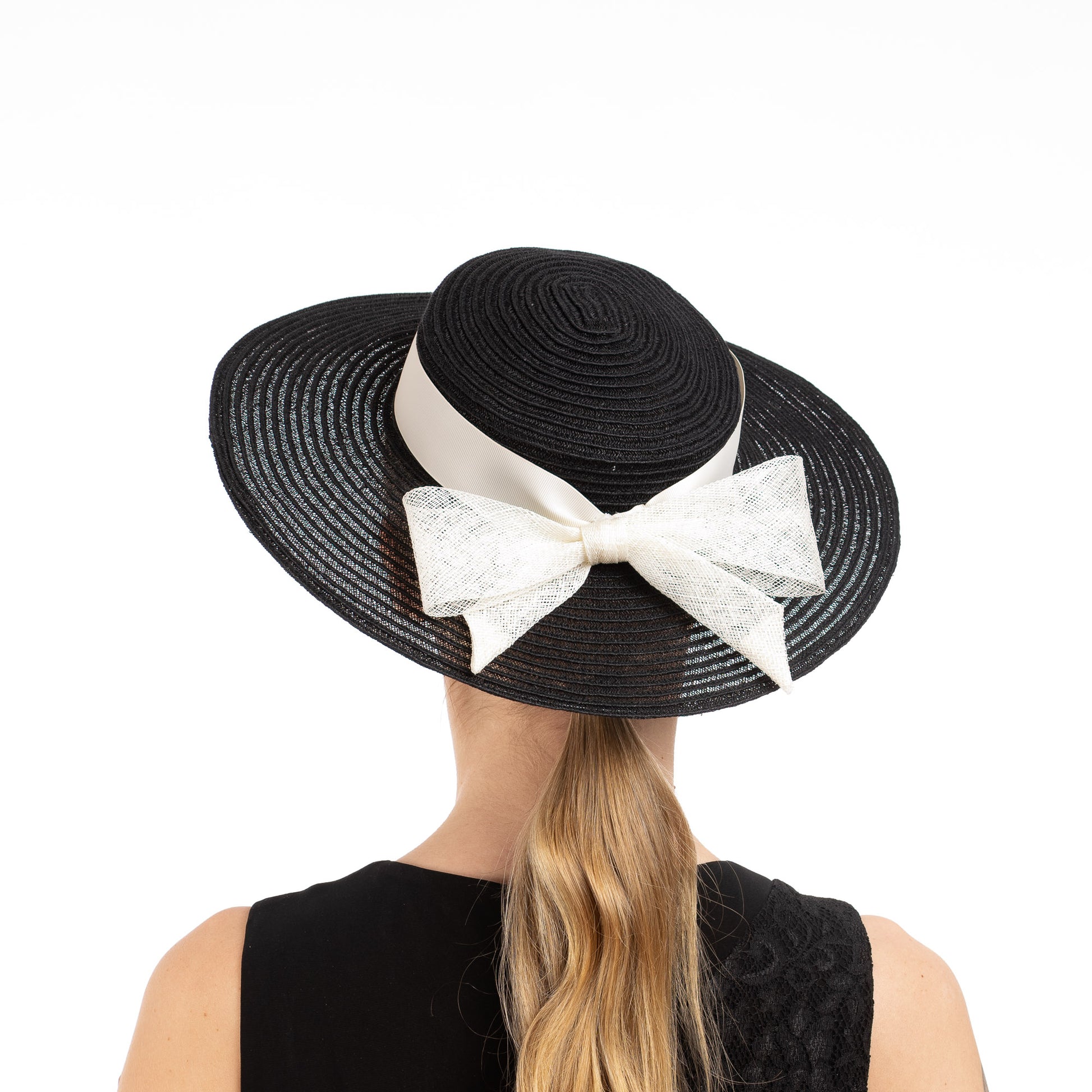 Black straw hat with a large white bow on a white background