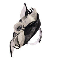 Black and white decorative headpiece on a stand against a light background